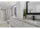 Bright bathroom with double vanity, marble countertop, walk in shower and modern fixtures at 6096 Kinlock Ave, Spring Hill, FL 34608
