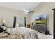 Comfortable bedroom with ceiling fan, TV, and view to the outdoor patio at 6096 Kinlock Ave, Spring Hill, FL 34608