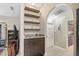 Arched hallway with floating shelves, a granite countertop, a built-in cabinet, and tile floor at 6096 Kinlock Ave, Spring Hill, FL 34608