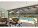 Back patio featuring wicker seating, screened in pool, and a waterfall feature at 6096 Kinlock Ave, Spring Hill, FL 34608