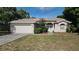 House exterior featuring a two-car garage and well-maintained lawn at 307 Killinger Ave, Spring Hill, FL 34606