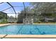 Inviting screened pool with a waterfall feature at 6096 Kinlock Ave, Spring Hill, FL 34608
