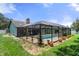 Home exterior showcasing a large screened pool and backyard at 6096 Kinlock Ave, Spring Hill, FL 34608