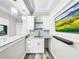 Modern basement bar with white cabinets, granite countertop and a built-in TV at 4260 Columbus Dr, Hernando Beach, FL 34607