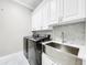 Clean laundry room featuring a farmhouse sink and modern appliances at 4260 Columbus Dr, Hernando Beach, FL 34607