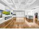 Open concept great room with hardwood floors, coffered ceiling, kitchen island, and fireplace at 4260 Columbus Dr, Hernando Beach, FL 34607