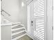 Interior entryway with modern staircase and white shutters at 4260 Columbus Dr, Hernando Beach, FL 34607