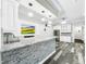 Long granite countertop basement bar with white shaker cabinets and stone feature wall at 4260 Columbus Dr, Hernando Beach, FL 34607