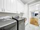 Laundry room with white cabinets, marble backsplash, and modern washer/dryer at 4260 Columbus Dr, Hernando Beach, FL 34607