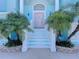 Front entrance with stairs, columns, and lush landscaping at 4260 Columbus Dr, Hernando Beach, FL 34607