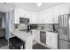 Updated kitchen with white cabinets, stainless steel appliances, and breakfast bar at 2207 Belleair Rd # A32, Clearwater, FL 33764