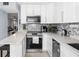 Bright kitchen with white cabinets, stainless steel appliances, and mosaic backsplash at 2207 Belleair Rd # A32, Clearwater, FL 33764