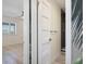 Hallway view of a bedroom with fan and bathroom with shower featuring on-trend wallpaper and fixtures at 4632 Marine Pkwy # 302, New Port Richey, FL 34652