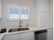 Bright kitchen featuring white cabinets, stainless steel appliances, and a sunny window at 4632 Marine Pkwy # 302, New Port Richey, FL 34652