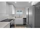 Bright kitchen with white cabinets, stainless steel appliances, and a view from the window at 4632 Marine Pkwy # 302, New Port Richey, FL 34652