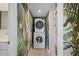Convenient laundry room featuring stacked washer and dryer with stylish tropical wallpaper at 4632 Marine Pkwy # 302, New Port Richey, FL 34652