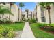 Condo building with walkway and tropical landscaping at 2207 Belleair Rd # A32, Clearwater, FL 33764