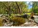 Serene backyard pond with wooden deck, waterfall, and lush landscaping at 11193 Baltimore St, Weeki Wachee, FL 34614