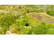 Aerial view showing home's location on a wooded lot near a pond at 11193 Baltimore St, Weeki Wachee, FL 34614