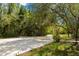 Curving concrete driveway surrounded by lush, green landscape at 11193 Baltimore St, Weeki Wachee, FL 34614