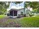 View of house exterior with landscaping and screened patio at 2727 Featherstone Dr # 2727, Holiday, FL 34691