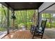 Spacious screened porch with rocking chairs, offering a tranquil wooded view at 7413 Gettysburg Dr, Weeki Wachee, FL 34607