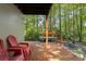 Wooden deck with red chairs and a view of the wooded backyard at 7413 Gettysburg Dr, Weeki Wachee, FL 34607