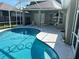 Relaxing kidney-shaped pool with a screened enclosure at 402 Knight Dr, Tarpon Springs, FL 34688