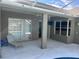 Covered patio with seating area, adjacent to pool and kitchen access at 402 Knight Dr, Tarpon Springs, FL 34688