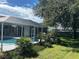 Inviting pool area with a screened enclosure and lush landscaping at 402 Knight Dr, Tarpon Springs, FL 34688