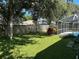 Landscaped backyard with a large tree and fenced-in pool at 402 Knight Dr, Tarpon Springs, FL 34688