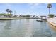 Tranquil canal view with palm trees and a boat dock at 6412 Yvette Dr, Hudson, FL 34667
