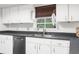 Modern kitchen with white cabinets, stainless steel appliances, and dark countertops at 4148 Batten Rd, Brooksville, FL 34602