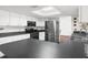 Modern kitchen with white cabinets, stainless steel appliances, and dark countertops at 4148 Batten Rd, Brooksville, FL 34602