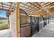 View of a row of horse stalls with metal gates at 4148 Batten Rd, Brooksville, FL 34602