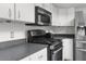 Modern kitchen with white cabinets, stainless steel appliances, and dark countertops at 4148 Batten Rd, Brooksville, FL 34602
