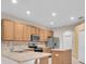 Well-lit kitchen featuring wood cabinets, stainless steel appliances, and tile flooring at 6419 Cardinal Crest Dr, New Port Richey, FL 34655