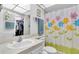 Clean bathroom with shower/tub combo, floral shower curtain and storage at 11937 Bayonet Ln, New Port Richey, FL 34654