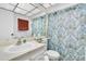 Clean bathroom with shower/tub combo, white vanity, and patterned shower curtain at 11937 Bayonet Ln, New Port Richey, FL 34654