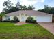 House exterior featuring a two-car garage and landscaped yard at 6075 Shingler Ave, Spring Hill, FL 34608
