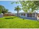 Spacious backyard with lush grass and a screened patio at 1037 Chelsea Ln, Holiday, FL 34691