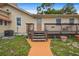 A quaint back deck with natural wood steps and railing leading to the home's entrance with a serene outdoor space at 1501 28Th N Ave, St Petersburg, FL 33704