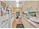 Functional kitchen featuring white cabinets, a sink and a window, and a refrigerator at 1501 28Th N Ave, St Petersburg, FL 33704