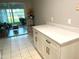 Kitchen with white cabinets and quartz countertops, overlooking a sunroom at 7278 Scotland Cir, Weeki Wachee, FL 34613
