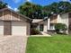 Two-car garage and front entrance with walkway at 7278 Scotland Cir, Weeki Wachee, FL 34613