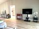 Living room with hardwood floors, TV stand, and access to kitchen at 7278 Scotland Cir, Weeki Wachee, FL 34613
