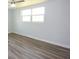 Spacious bedroom with wood-look floors and large windows at 2252 Society Dr, Holiday, FL 34691