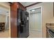 Sleek black refrigerator in kitchen with dark wood cabinetry at 9 Grace St, Crystal Beach, FL 34681