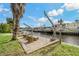 Brick paved waterfront patio with boat lift and relaxing seating area at 9 Grace St, Crystal Beach, FL 34681