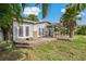 Home's backyard with patio, stonework, and tropical landscaping at 9 Grace St, Crystal Beach, FL 34681